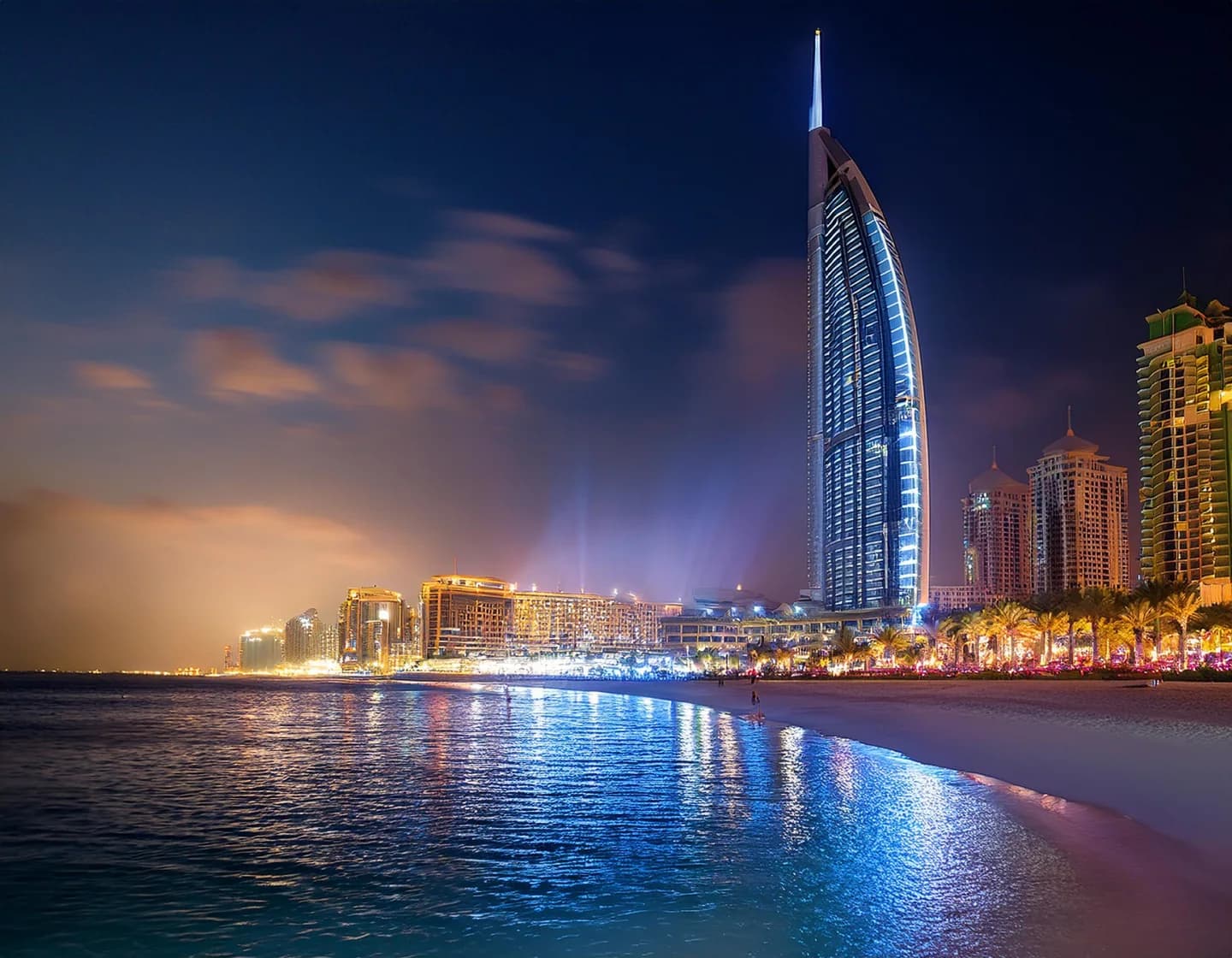 The Burj Al Arab lit at night above the beach in Dubai